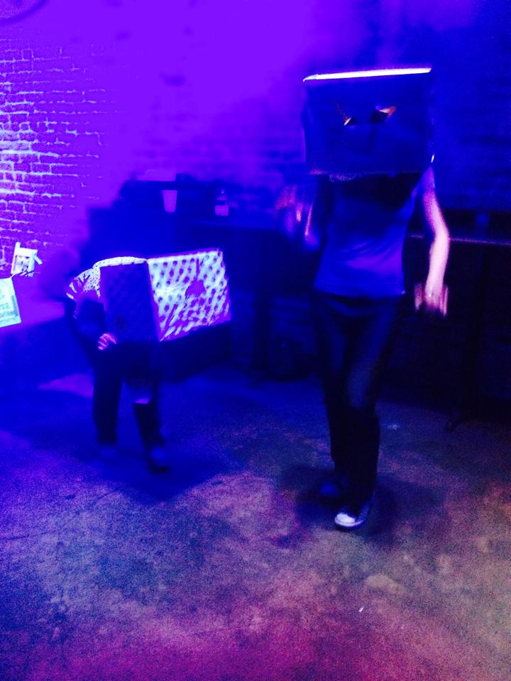 I'm dancing with a cardboard box on my head with another person.