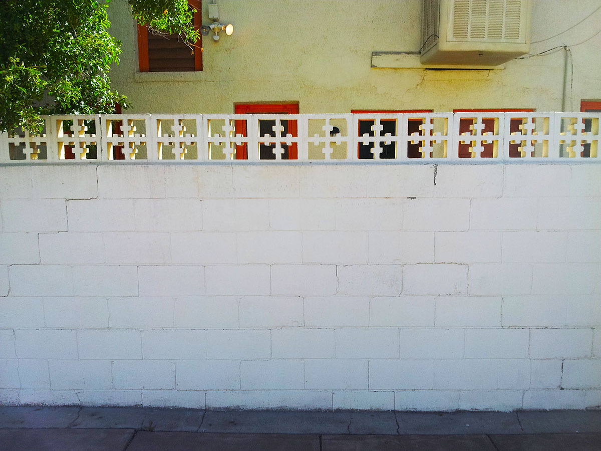 A stone wall with an interesting design at the top.