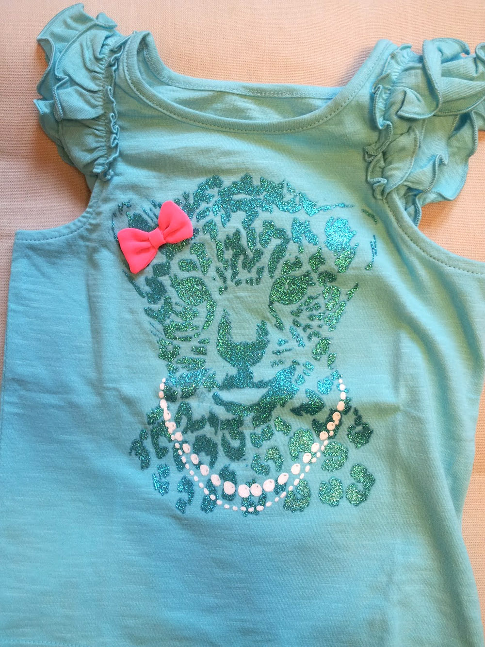 Light blue ruffled toddler's shirt with a sparkly leopard printed on it.