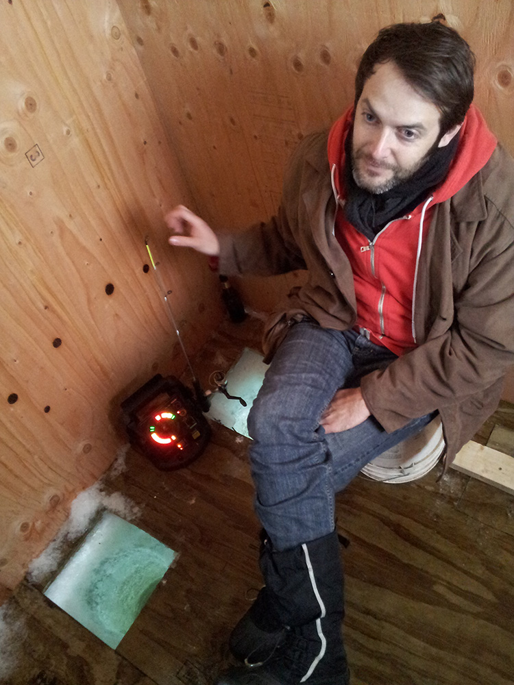 Arthur ice fishing in a plywood ice house.