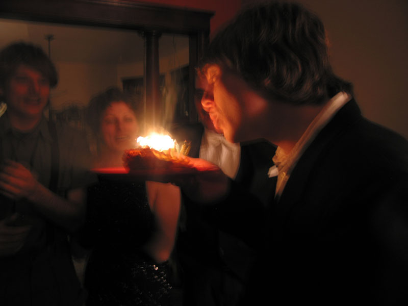 Sam blowing out candles in a piece of lasagna