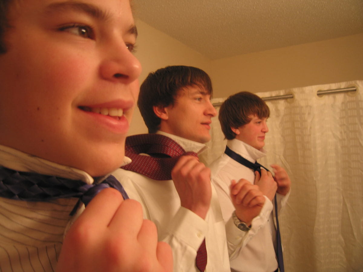 Ben showing Joe and Rob how to tie ties, shot of their faces