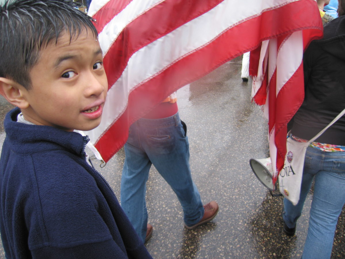 Young boy smiling by the American flag