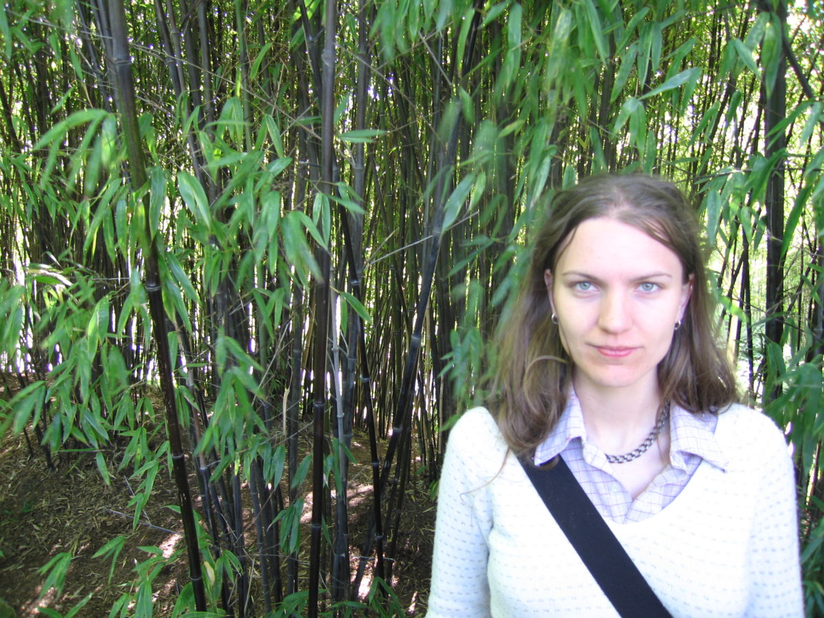 Meg posing before a thicket of bamboo.