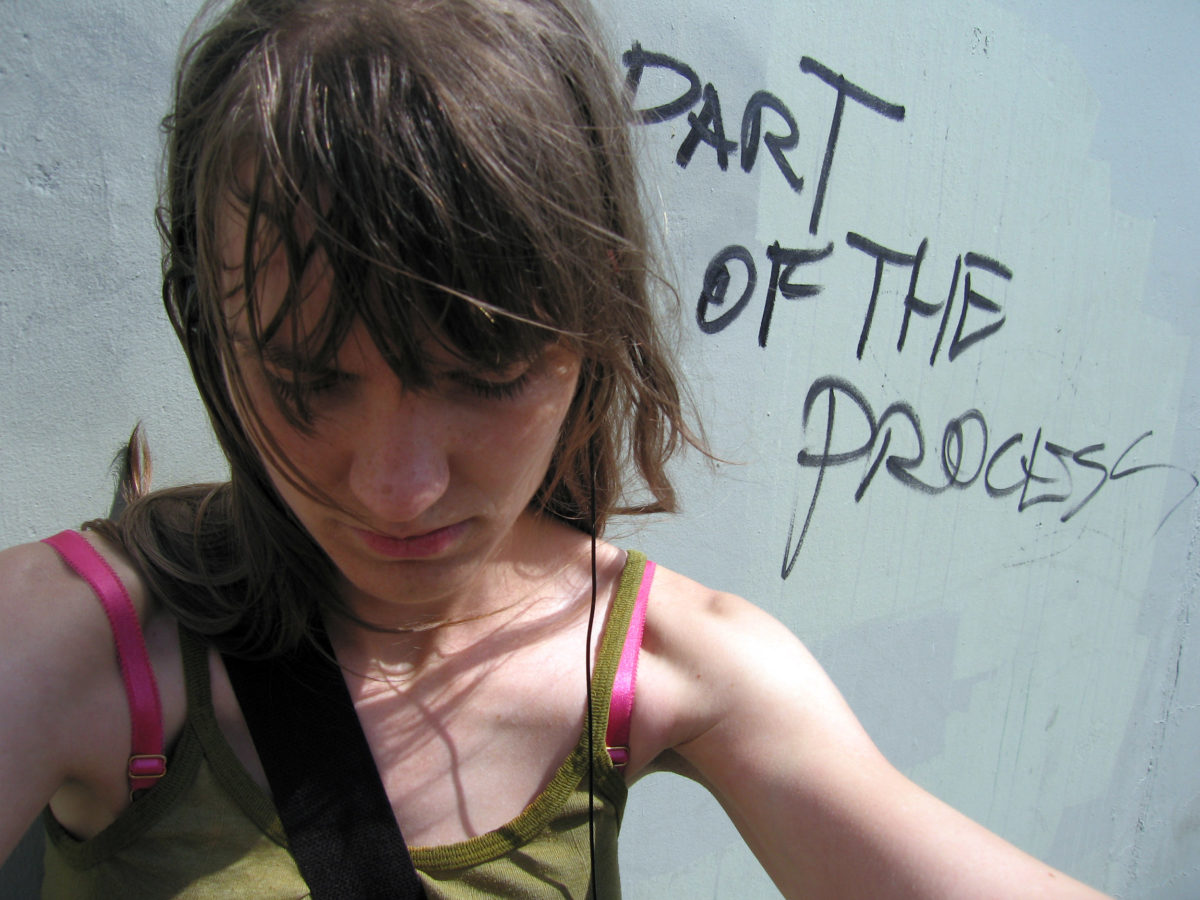Meg with grafitti behind her, "Part of the Process"