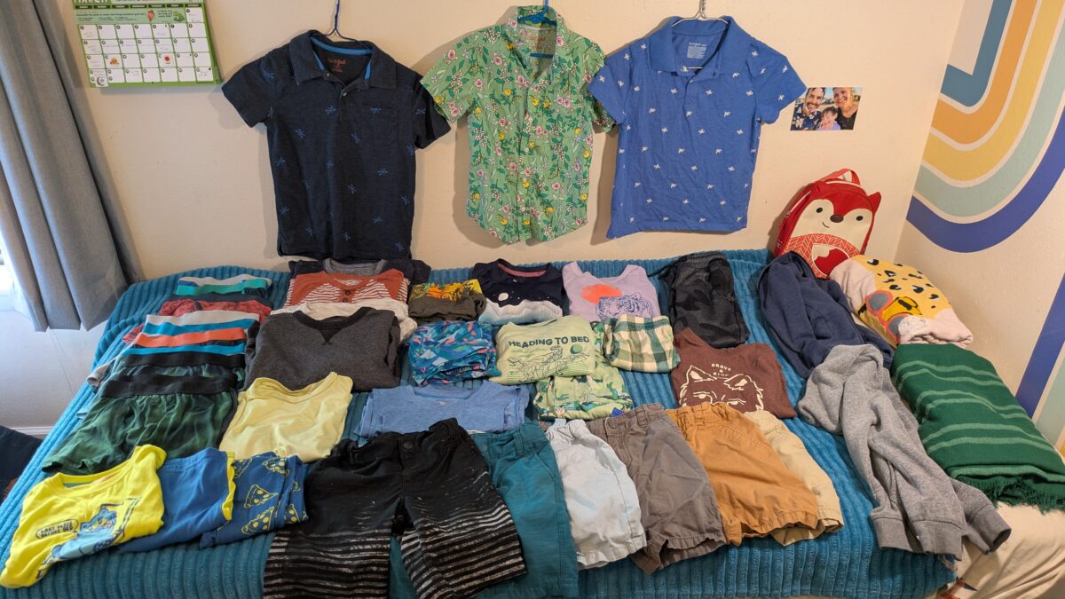 A child's bed covered in clothes from Target.