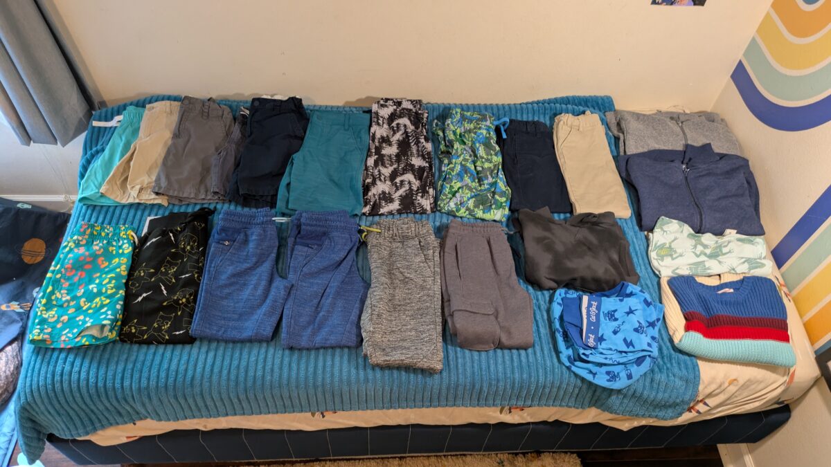 A child's bed covered with even more clothes from Target.