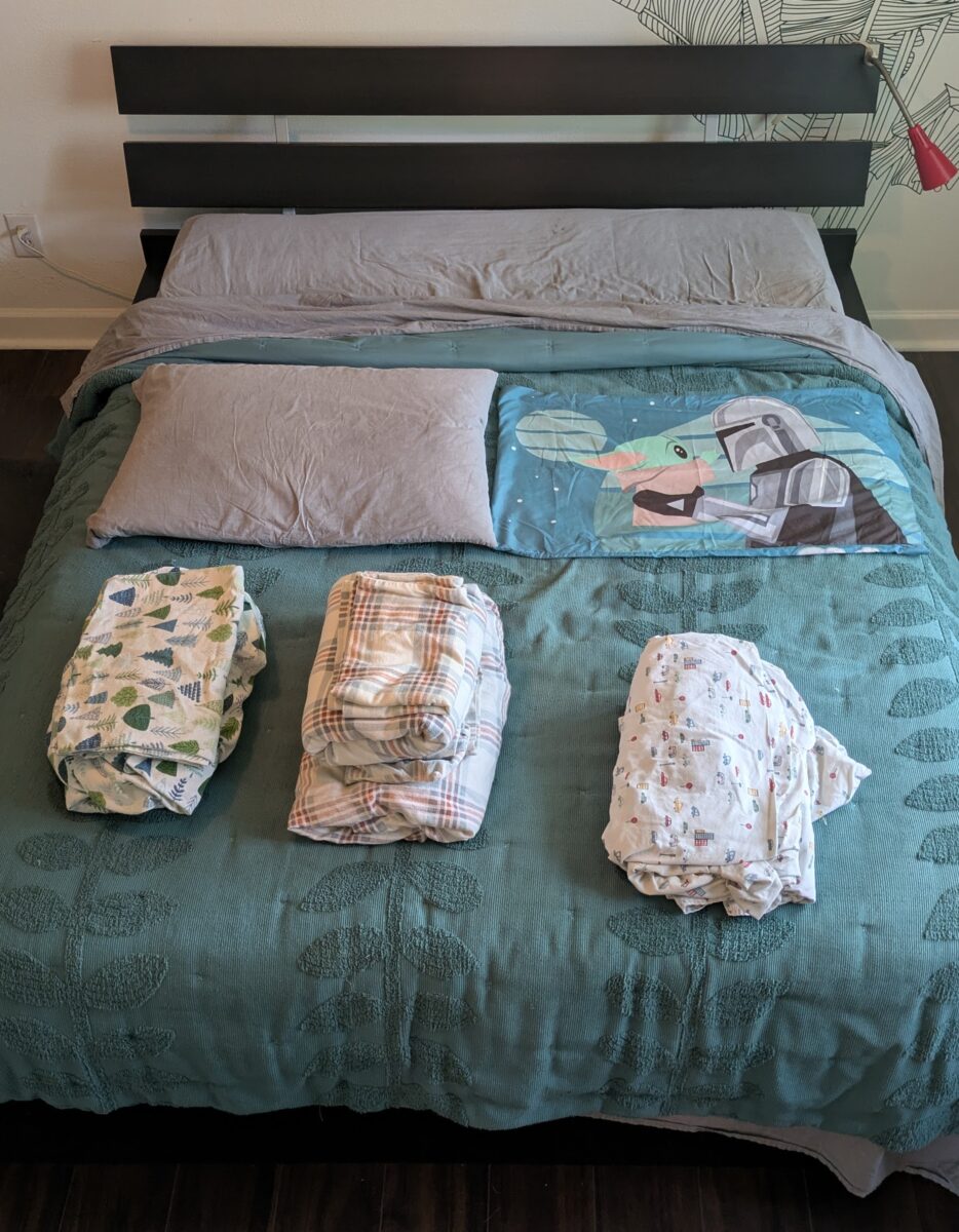 A bed with sheets and bedspread and pillow from Target.